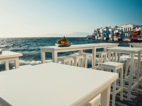 A white table and chairs sitting on the beach