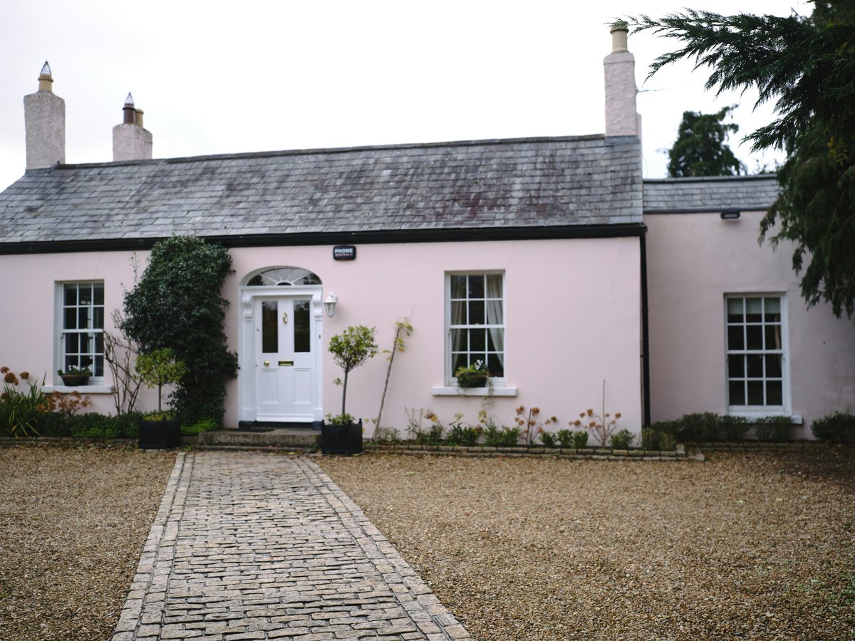 a pink house with a white door and windows