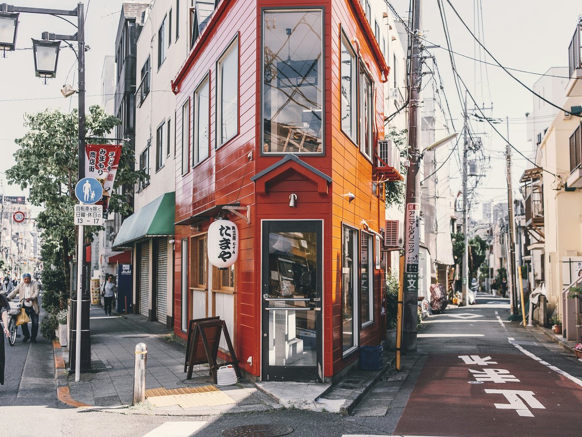 woman standing walking beside red building
