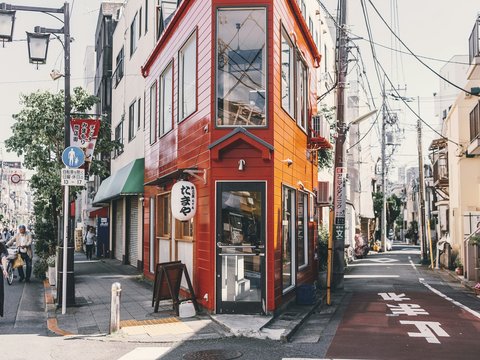 woman standing walking beside red building