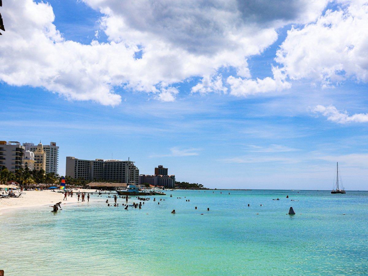 People enjoying a sunny day at a tropical beach resort.