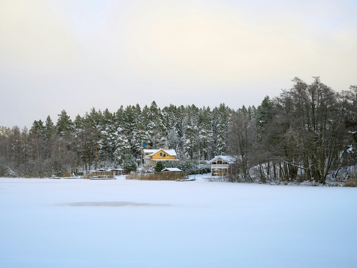 a snow covered field with a house in the background