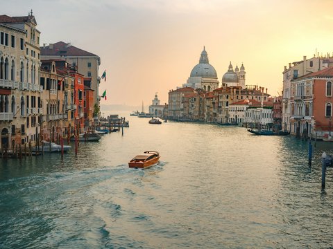a river with boats in it and buildings around it with Grand Canal in the background