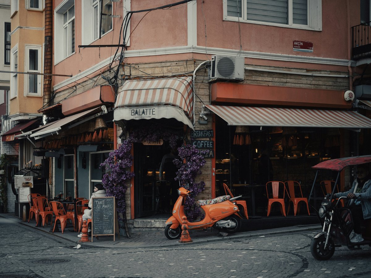 an orange scooter parked in front of a restaurant