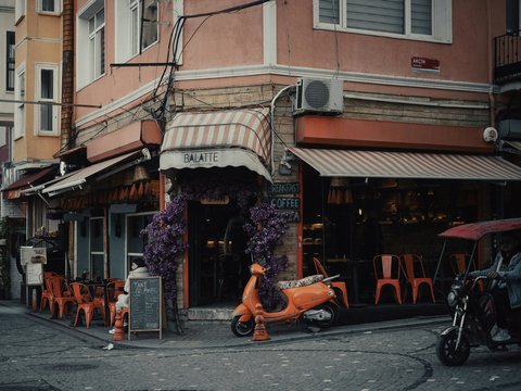 an orange scooter parked in front of a restaurant