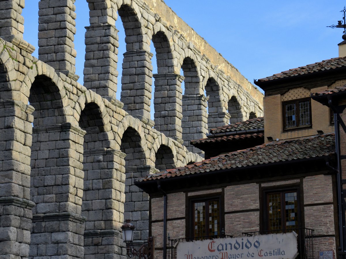 a large stone bridge over a river next to a tall building