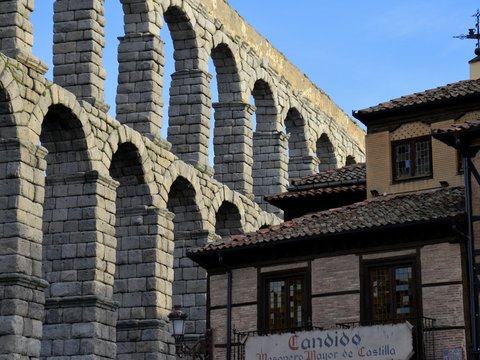 a large stone bridge over a river next to a tall building