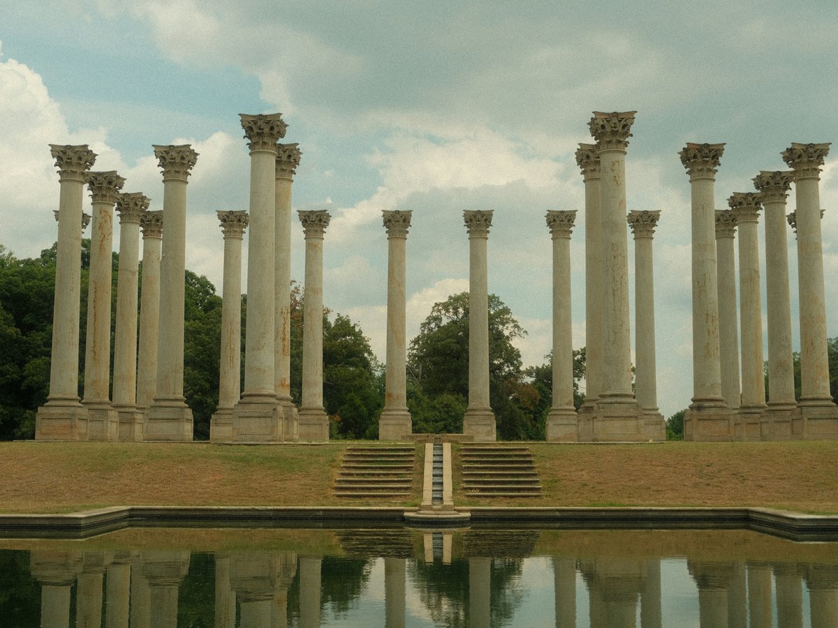 A row of stone pillars sitting next to a body of water