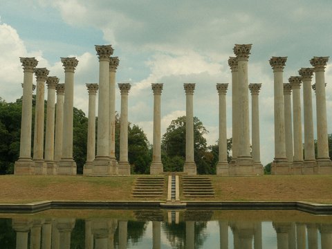 A row of stone pillars sitting next to a body of water