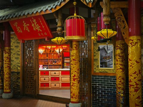 A chinese style building with a birdcage hanging from the ceiling