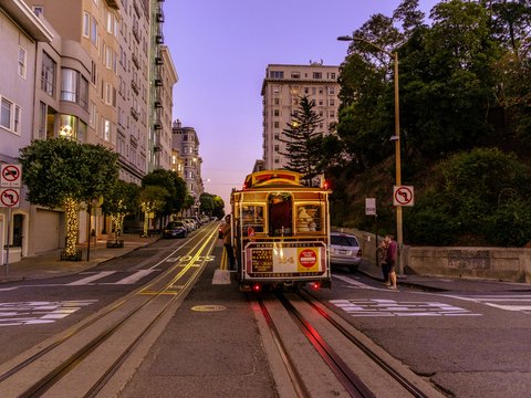 A cable car travels down a san francisco street.