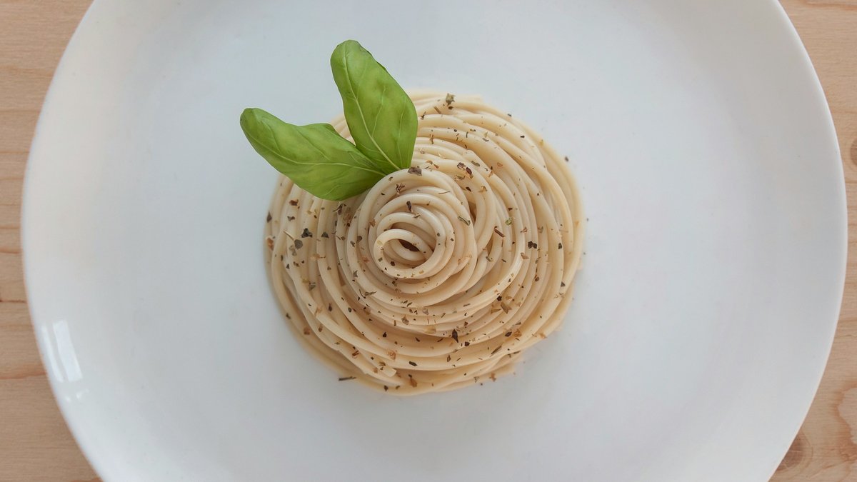 A steaming bowl of hand-rolled Roman pasta glossed in buttery sauce and cracked black pepper, rustic linen and a weathered trattoria table completing a warm, lived-in still life
