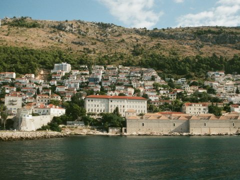 a view of a city on a hill next to a body of water