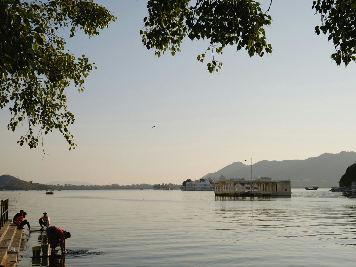 a group of people standing on a dock next to a body of water