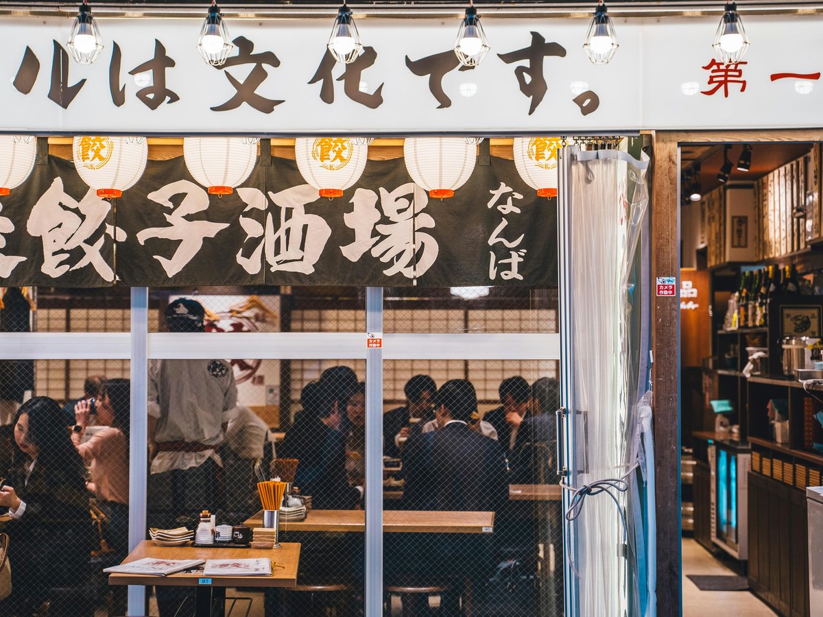 a group of people sitting at a table in front of a restaurant