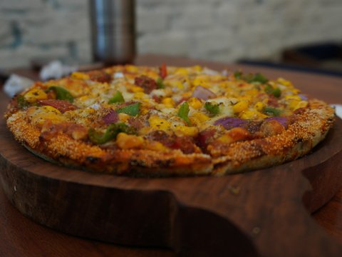 a pizza sitting on top of a wooden cutting board