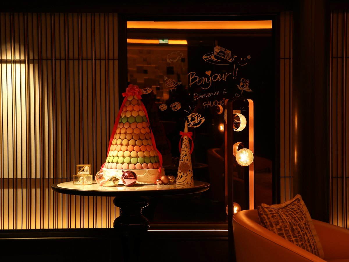 A tall pyramid of colorful macarons on a table.