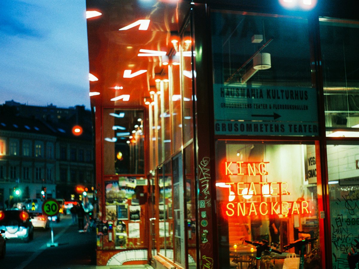 Neon sign glows in a storefront at night.