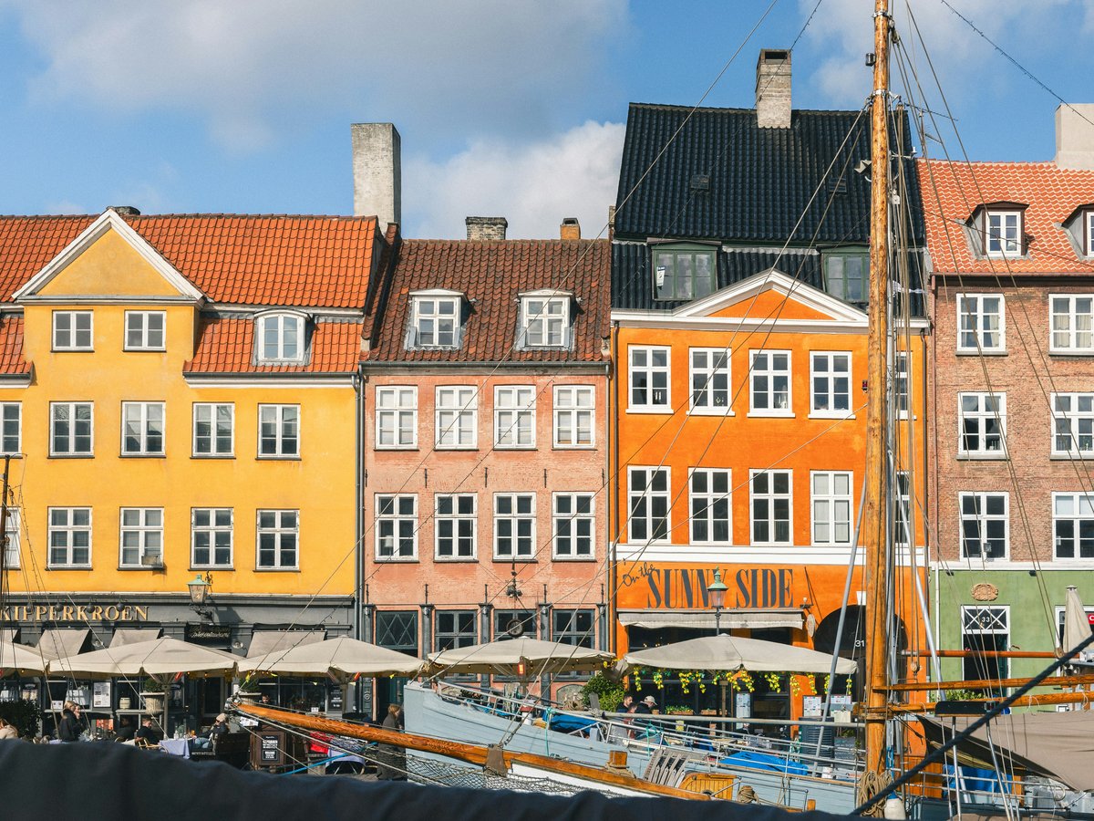 Colorful buildings line a canal with boats.