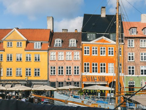 Colorful buildings line a canal with boats.