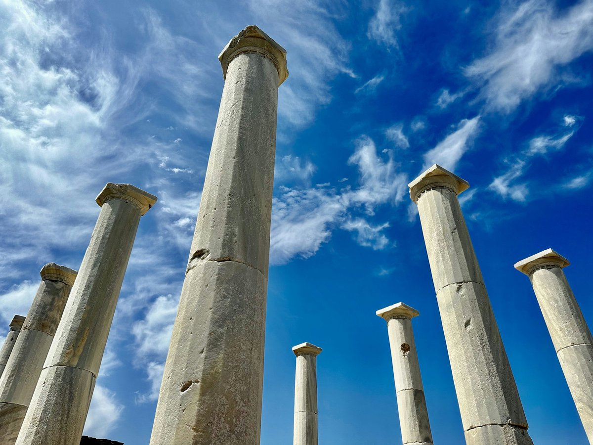 a group of tall white pillars under a blue sky