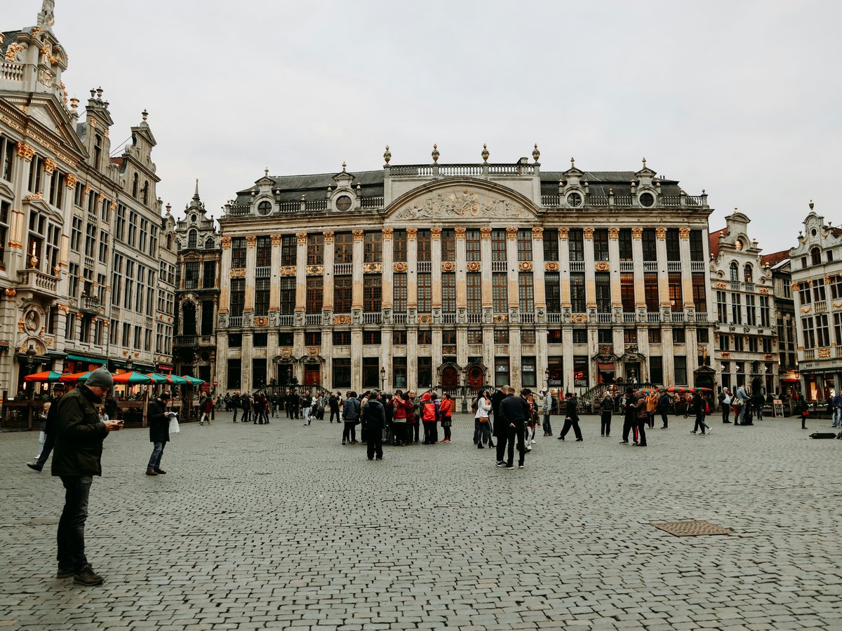 A group of people walking around a large building