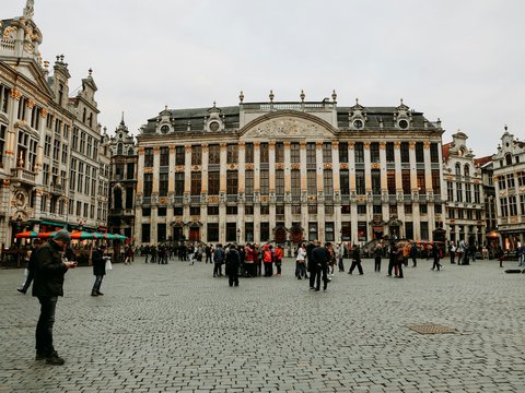 A group of people walking around a large building