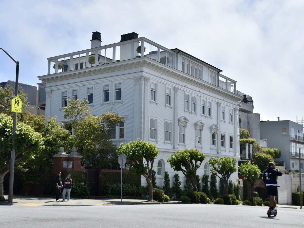 A large white building is situated on a street.