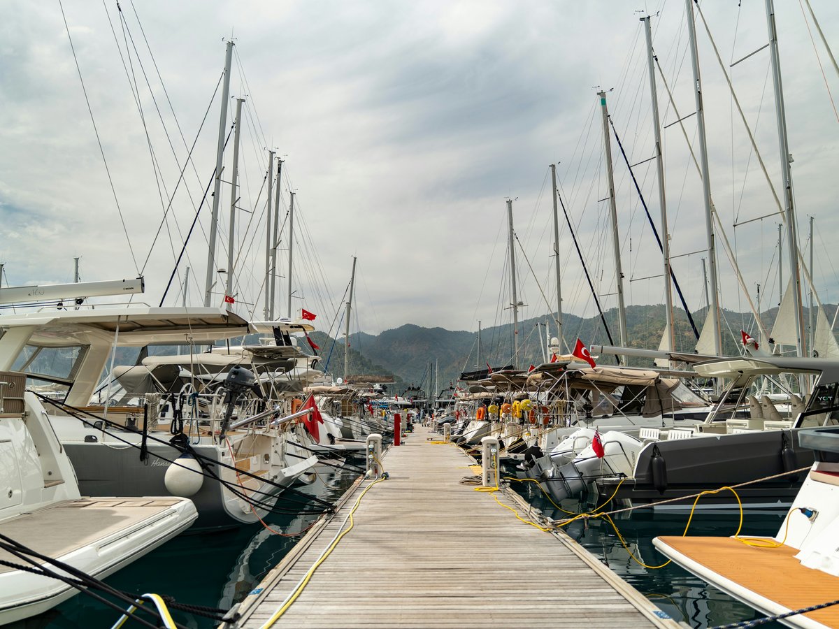 Boats are docked at a pier on a cloudy day