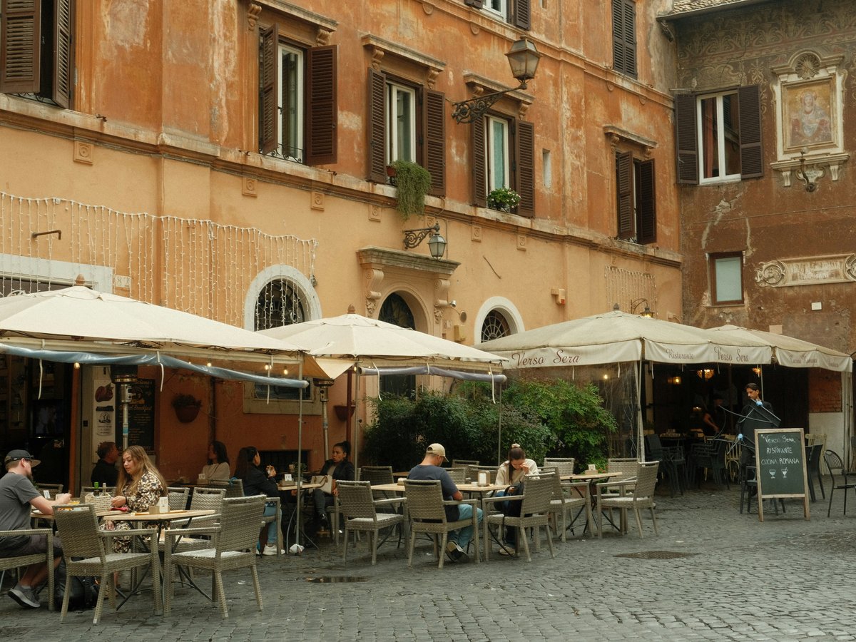 Restaurant tables sit outside a building.