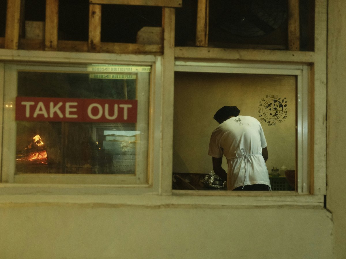 a man looking out of a window at a sign