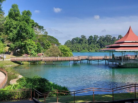 a gazebo sitting on top of a lake next to a forest