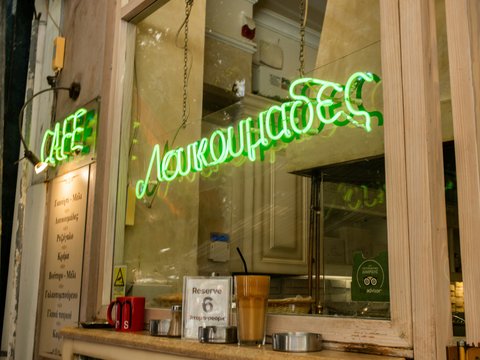 Green neon sign for loukoumades cafe in athens