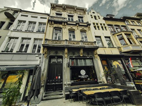 a row of buildings with tables and chairs in front of them