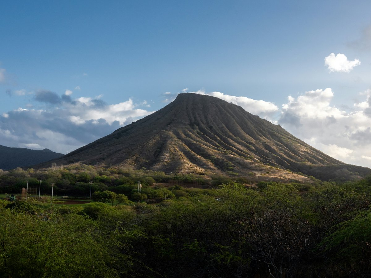 A large, barren mountain under a blue sky.