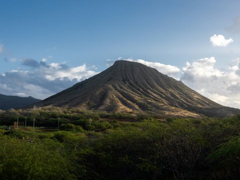 A large, barren mountain under a blue sky.