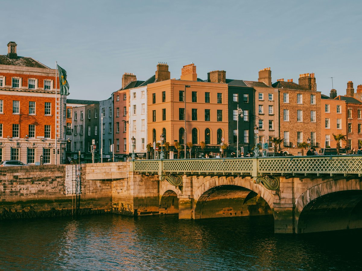 a bridge over a body of water with buildings in the background