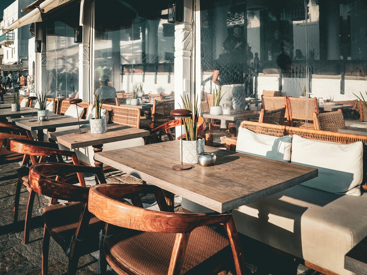 A restaurant with tables and chairs and an umbrella