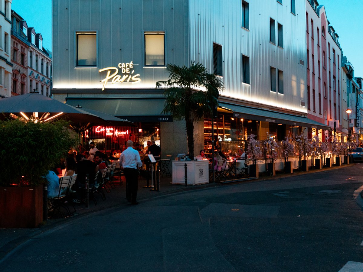 a group of people sitting outside of a restaurant