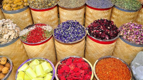 Deira Spice Souk baskets brimming with chamomile, dried roses, saffron, hibiscus, crushed chili, paprika and crystallised citrus, the rough woven rims stamped with red bands and staged in tight overlapping rows