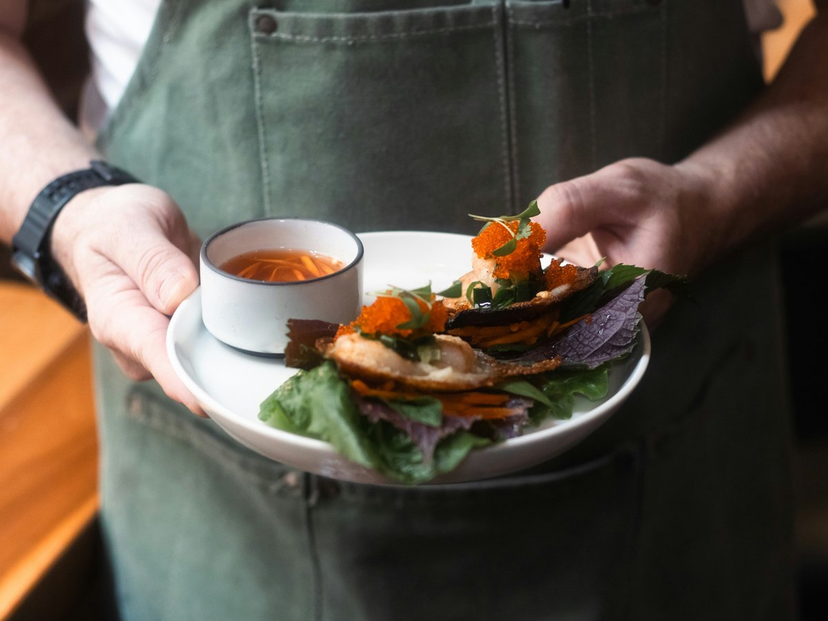A person holding a plate with food on it
