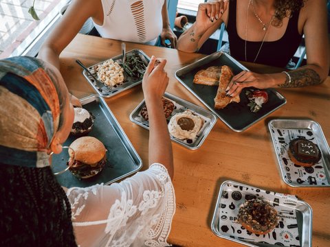 a group of people sitting around a table eating food
