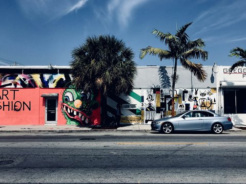 a car parked in front of a building with graffiti on it