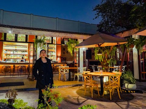 Woman poses outside of a beautiful restaurant.