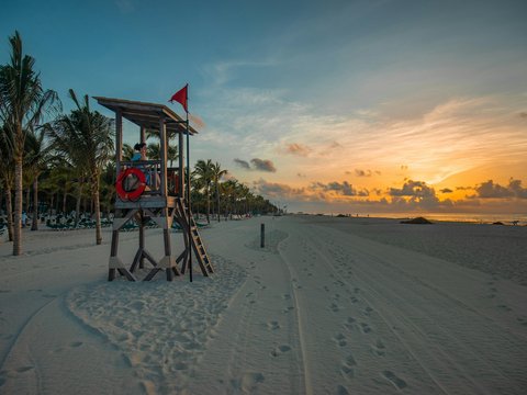 lifeguard sitting on lifeguard shed near seashore