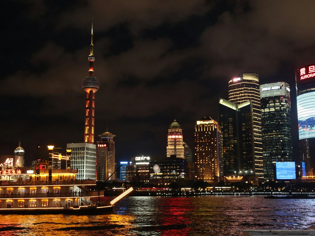 a boat traveling down a river next to tall buildings