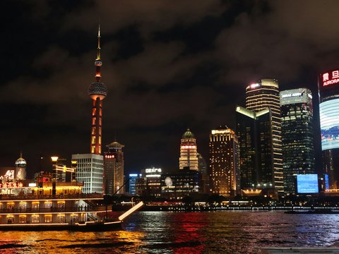 a boat traveling down a river next to tall buildings