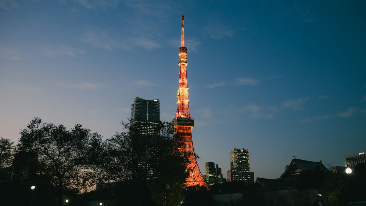 Tokyo Tower blazes orange against a cobalt-to-rose dusk sky, its lattice of steel rising over Minato's rooftops as the last daylight slips behind the distant skyline