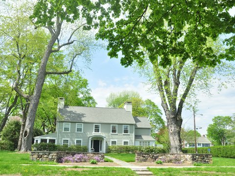 white and gray house near green trees during daytime