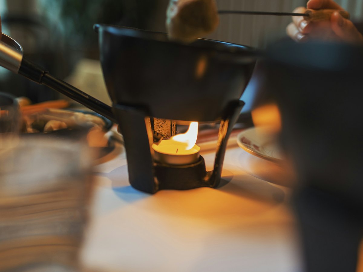Fondue pot with flame on a table
